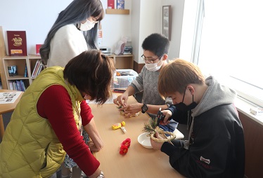 作製のサポートをする介護支援コースの学生(右)