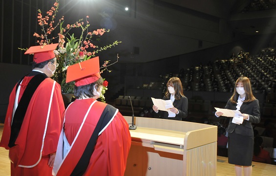 誓いの言葉を述べる看護リハビリテーション学部理学療法学科1年の甲斐亜朱姫さん(左)と短期大学部社会福祉学科1年の杉山かりんさん