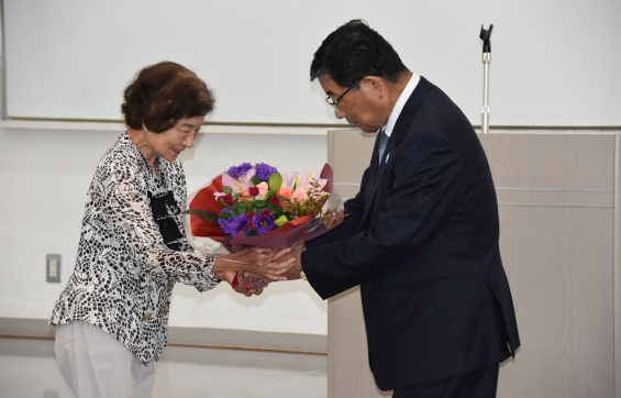 古田氏の誕生日を祝って花束を贈る片桐多恵子・済美学院長