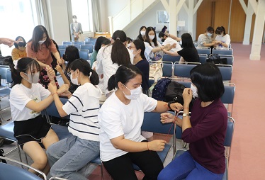 2人1組で知恵の輪を行う留学生と日本人学生